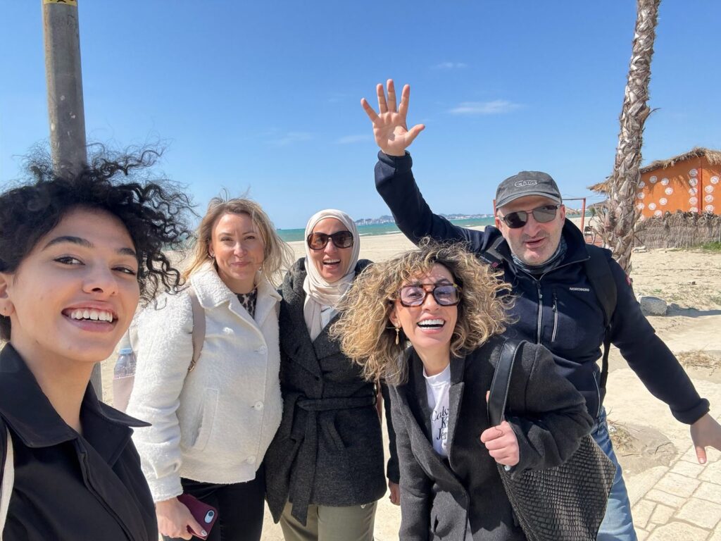 Few adults smiling and waving outdoor, windy weather