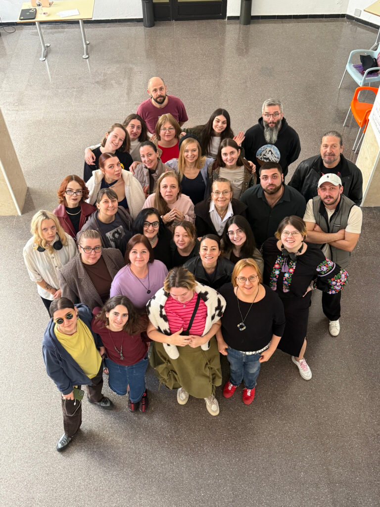 A photo from a top, group of participants in a big room looking up